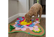 Dog interacting with a snuffle mat on the floor.