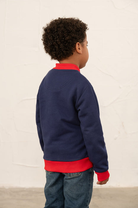 Child wearing a navy and red jacket 